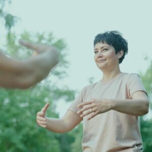 Mujer sonriente practicando los sonidos curativos, sintiendo el alivio de las señales típicas en menopausia y el equilibrio emocional.