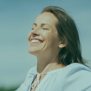 Mujer sonriente de más de 40 años, irradiando confianza y serenidad. Una imagen que celebra la belleza y sabiduría en la etapa de la menopausia, vista como una transformación natural y empoderadora.